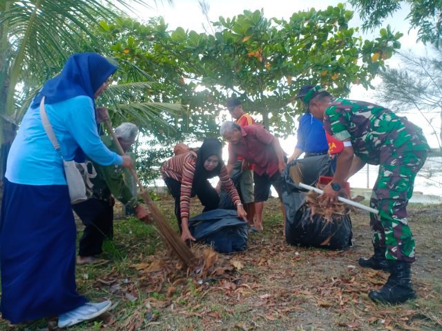 Babinsa Kelurahan Kemboja Sertu Nurdin Kama ikut bersih-bersih di pesisir pantai Rimba Jaya, Rabu (21/06/2023)