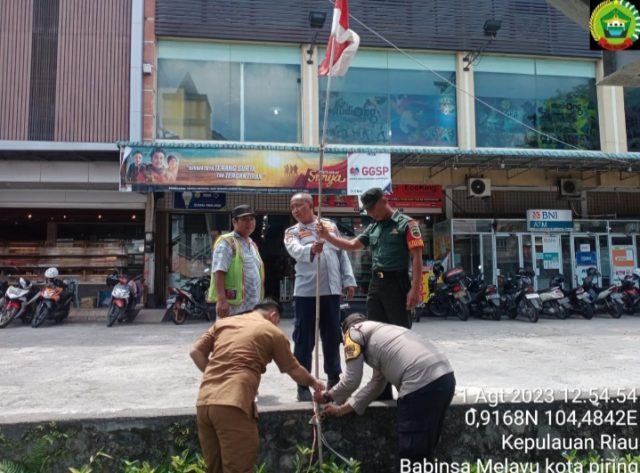 Babinsa Kelurahan Melayu Kota Piring Koramil 01 Kota bersama perangkat Kelurahan memasangkan bendera merah putih, Selasa (01/08/2023)