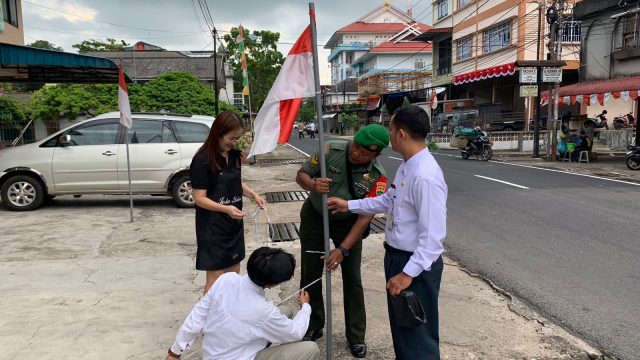 Babinsa Kelurahan Kemboja Koramil 01 Kota bantu pasang bendera merah putih, Rabu (02/08/2023)